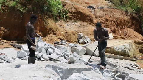 BO, SIERRA LEONE - 17 OCT 2021: Men break stone Rock quarry Kenema Sierra Leone hard labor. Sierra Leone, Africa Quarry where rock and stone is mined for commercial use in roads, cement landscape work