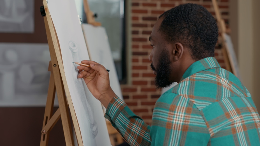 Portrait of african american student drawing contemporary sketch at art workshop lesson. Creative artwork practice with pencil on canvas and easel to learn to draw inspiration model.