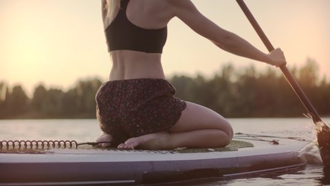Travel Paddles Paddleboard. Sup Board Journey. Young Woman Relaxing On Sup Surf Swimming. Watersport Floating On Surfboard At Sunset. Girl Stand Up Paddle Boarding. Warm Summer Beach Vacation Holiday