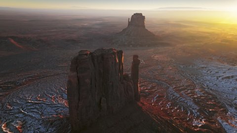 Monument Valley, Utah travel, USA tourism. Excellent aerial over cowboy native valley overlooking wild west landscape at sunrise. 4K flying fast over desert toward red rock mesa revealing mountains