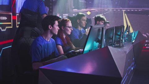 Gamers teammates esportsman players smiling and clenching fists then putting on headsets and starting to play video game during professional esports competition