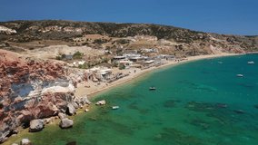 Aerial drone video of scenic colourful volcanic rocky bay and emerald sandy beach of Paleochori a natural vacation paradise with resorts and water sport facilities in island of Milos, Cyclades, Greece