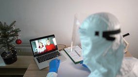Male doctor in the laboratory uses a laptop gadget for a video call with his parents. Concept of christmas in the hospital, vaccine research for covid-19, a new virus strain. Christmas and covid - Powered by Shutterstock - Get 15% off with code: PIKWIZARD15
