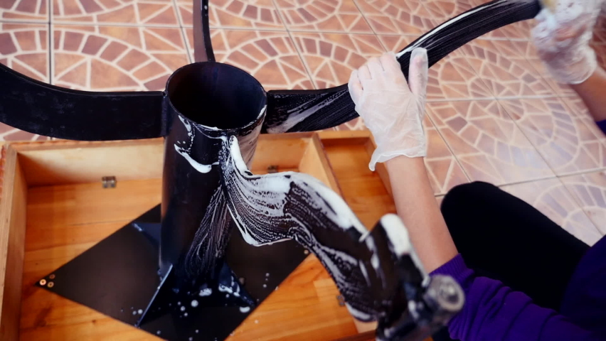 young asian girl in gloves washes the table with detergent and foam with a rag