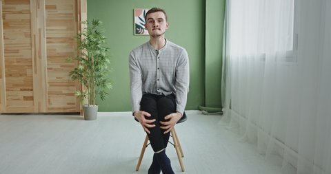 Anxious man expressing impatience and sitting on chair