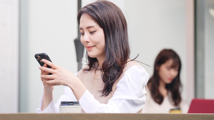 Young asian woman using a smart phone in cafe. Royalty-Free Stock Footage #1086169052