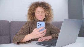 Happy woman browsing internet on mobile phone. Cheerful white female using modern smartphone with toothy smile. Freelancer person communicating online with new cellphone gadget