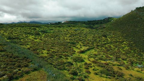 Stunning areal view of lush green meadows near the edge of a volcano crater in Gran Canaria of Canary islands.