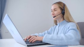Friendly online support operator talking on headset and web camera. Helpdesk specialist speaking with client online with cheerful smile in 4k stock video. Freelancer woman doing video call with webcam