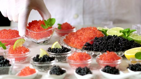 Caviar. Tasting salmon red caviar and black beluga sturgeon salted roe. Set of delicious snacks on banquet, close up. Expensive delicacy, serving table Bowls with red and black caviar on tasting tablу