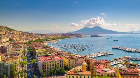Naples, Italy. August 31, 2021. View of the Gulf of Naples from the Posillipo hill with Mount Vesuvius far in the background Boats come in and out to the marina. Time lapse video with panning effect.