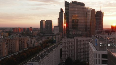 Slide and pan footage of modern high rise buildings with glossy facades reflecting setting sun. Warsaw, Poland