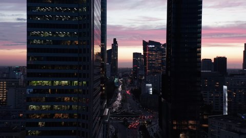 Amazing picturesque colourful twilight sky behind downtown skyscrapers. Forwards fly above busy street. Warsaw, Poland