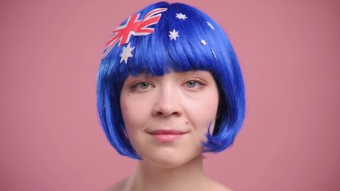 Australian patriot woman. Portrait of young smiling female in wig with national symbols of Australia.