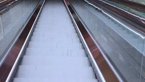 Close up slow motion 4K of metal escalator is moving up to the upper floor in department store or train station with beautiful sun light, it shows concept of transportation for urban life in the city.