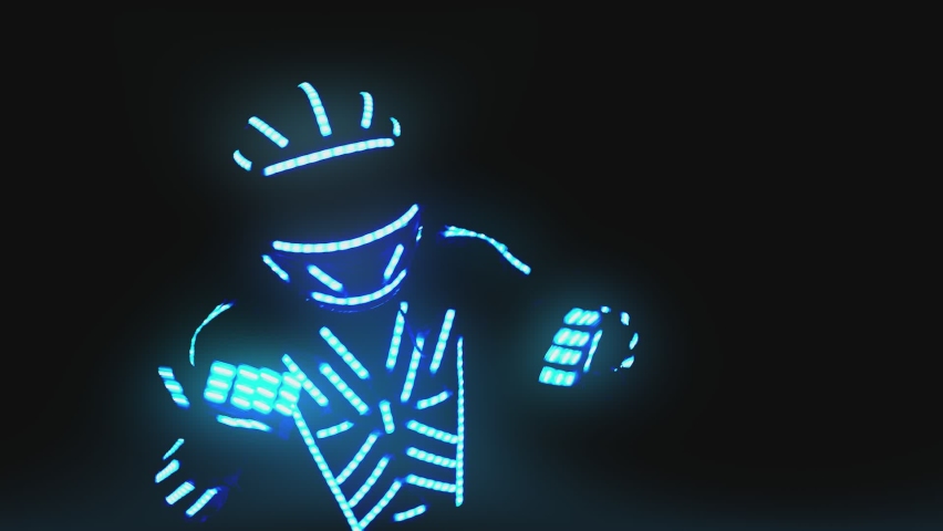Man dressed in led illuminated costume with colorful lights dancing and moving inside dark interior or club . Dancer guy wearing clothing with neon lights on his body and dances . Shot on ARRI camera | Shutterstock HD Video #1086190253