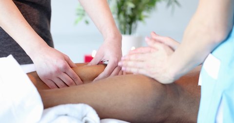 Female hands doing massage of male shins in beauty salon closeup 4k movie slow motion