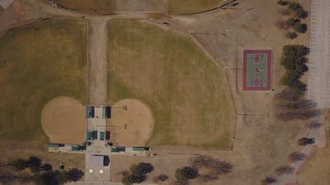 4K aerial of an empty baseball field on a cold, sunny day. Birds eye view looking straight down showing the full baseball diamond.