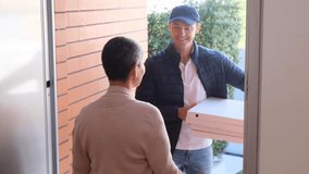 Cheerful courier in cap delivering pizza to woman at her home. Back view of woman standing in doorway, receiving food from delivery man and talking . Online shopping, food delivery concept - Powered by Shutterstock - Get 15% off with code: PIKWIZARD15