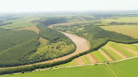 Spectacular view of a winding river flowing across the plain from a bird's eye view. Footage of scenic Dniester canyon, Ukraine, Europe. Cinematic drone shot. Filmed in UHD 4k video. Beauty of earth.