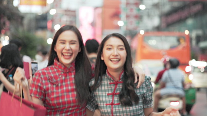 Asian woman in cheongsam dress with shopping bag. happy smiling woman holding colorful shopping bag in  china town.People traveling in city lifestyle at outdoor at China town street food market. 