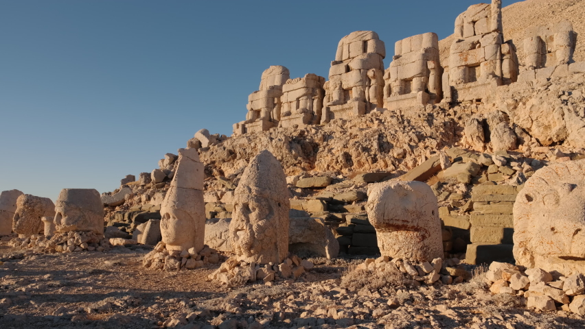 Antique statues on Nemrut mountain at sunrise in Turkey. Ancient stone head close-up at the top of 2150 meters high Mount Nemrut, Eastern Anatolia, Turkey. Slow panning.  Royalty-Free Stock Footage #1086208868