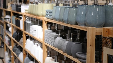 Variety of bathroom accessories displayed on shelving in household goods store. Concept of organizing comfortable home space