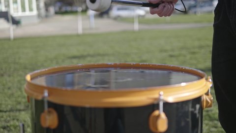 Slow Motion Shot of Drum Hit and Splashing Water. Drummer plays, hitting drums with water on it.