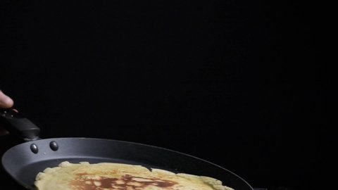 Flipping over baking french crepes pancake close up slow motion