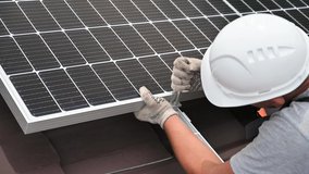 Man worker mounting photovoltaic solar moduls on roof of house. Close up of electrician installing solar panel system outdoors, tightening clamp with hex key. Concept of alternative, renewable energy. - Powered by Shutterstock - Get 15% off with code: PIKWIZARD15
