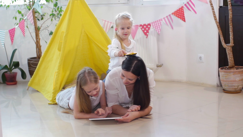 a young loving mother and her daughter are painting Easter eggs in the kitchen and preparing for the Easter holiday.