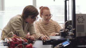 Lockdown of Caucasian schoolboy and his young female teacher sitting at desk in classroom and using laptop for analysis of program code boy made for his robot - Powered by Shutterstock - Get 15% off with code: PIKWIZARD15