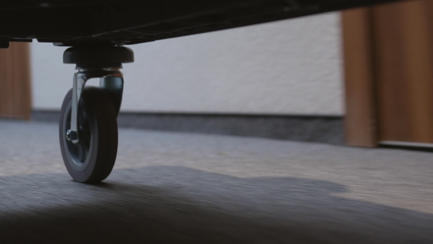 A close-up of the wheels of a guest luggage trolley in a hotel.The cart rolls down the corridor of the hotel