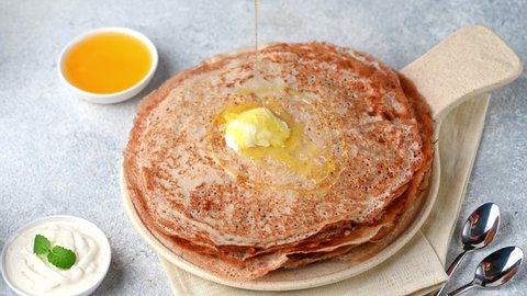 Pancakes with maple syrup. Pouring syrup on pancakes. Pouring honey on crepes. Maslenitsa blini. Shrovetide holiday. Shrove tuesday. Pancake day.