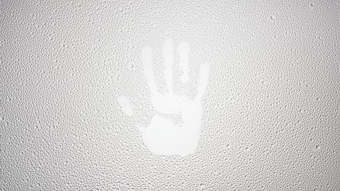 Handprint printed on the wet glass blown off with air stream on grey background | shower concept