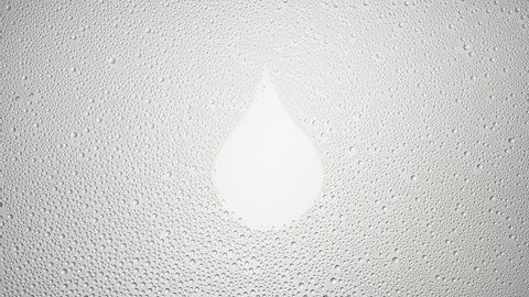 Drop shape printed on the wet glass blown off with air stream on grey background | moisturizing concept