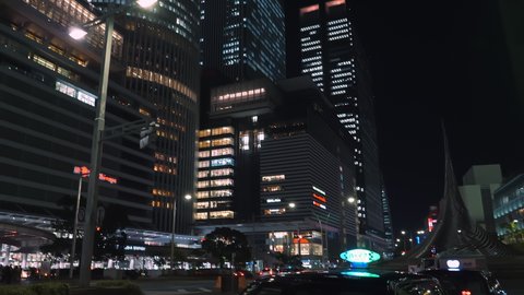 Nagoya.Japan-October 31.2019: View of skyscrapers in the downtown of Nagoya in Japan. Beautiful cityscape. Busy metropolitan life concept. Nighttime. Camera tilting upwards while turning left.