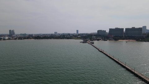 Aerial footage sliding to the left revealing the Pattaya Fishing Dock and the city of Pattaya in Chonburi from a distance, Thailand