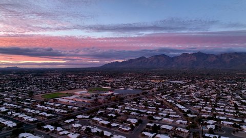 Cinematic slowly panning drone shot during sunset of Tuscon Arizona, starting on the mountains