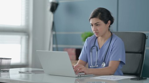 Indian Female Doctor having Headache while Working on Laptop