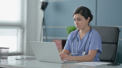 Indian Female Doctor having Back Pain while using Laptop in Office