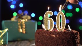 Number sixty birthday candle on sweet cake on the table, 60th birthday. Fire from the lighter, blow out the holiday candle. - Powered by Shutterstock - Get 15% off with code: PIKWIZARD15