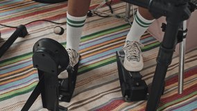 Legs of unrecognizable student wearing sneakers and high socks playing electronic drums, using bass drum pedal - Powered by Shutterstock - Get 15% off with code: PIKWIZARD15