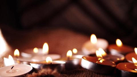 Tealight candles arranged for meditation on warm background medium slow motion shot selective focus