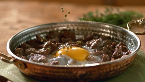 Fried Egg with Meat - Spices are thrown on the Fried Fried Egg with Meat. Turkish roasted meat (kavurma).