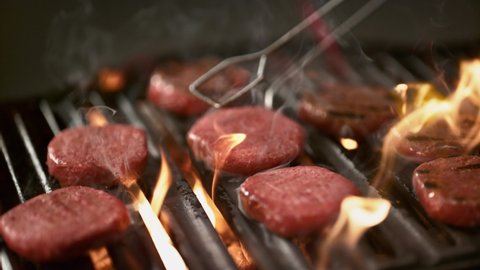 Traditional delicious dish Meatballs, cooked on the grill. Beef burgers cooked on a flaming barbecue grill shot with a super slow motion 4K macro lens. 