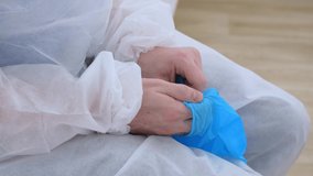 Close-up of latex disposable gloves is put on by a doctor to work with patients. A paramedic wears gloves to work in a covid hospital. Help for those affected by Coronavirus