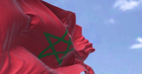 Detail of the national flag of Morocco waving in the wind on a clear day. North African Country. Patriotism. Selective focus. Seamless Slow motion