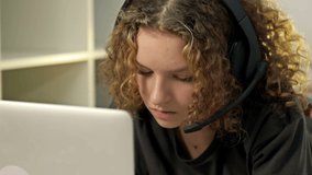 Teenage girl using laptop and wearing headphones. Modern technologies and the concept of leisure, education and communication.