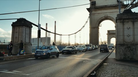 Paris, France - January 2022: Cars moving on bridge, timelapse with urban traffic in Paris. Cityscape in rush hour transport movement afternoon. Traffic on road.